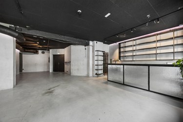 Romslig serveringsareal på gateplan med eksisterende bar og fleksible innredningsmuligheter.