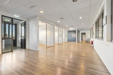 Funksjonell planløsning med åpent arbeidsareal og separate rom med glassvegger.