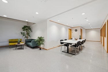 Lyst og innbydende fellesareal med sittegruppe og plass til uformelle møter.