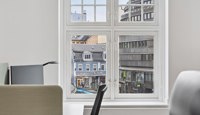 Arbeidsplasser med store vinduer og utsikt mot bymiljø