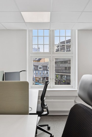 Arbeidsplasser med store vinduer og utsikt mot bymiljø