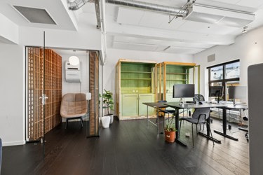 Sjarmerende kontorareal med store vinduer og fleksible muligheter for arbeidsplasser.