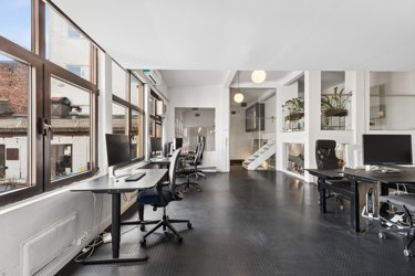 Lyst kontorlandskap med gode lysforhold og flere soner for arbeidsplasser.