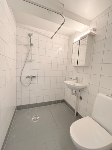 Flislagt bad med dusj og varmekabler.